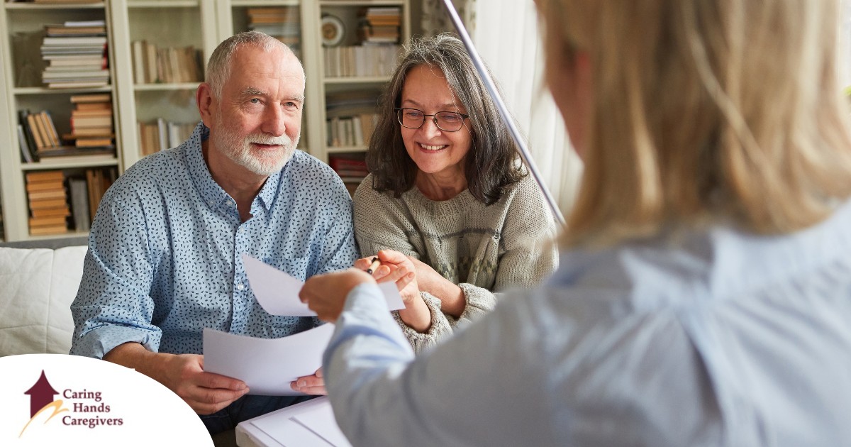 An older couple receives and considers papers from a woman, representing someone considering long-term care insurance.